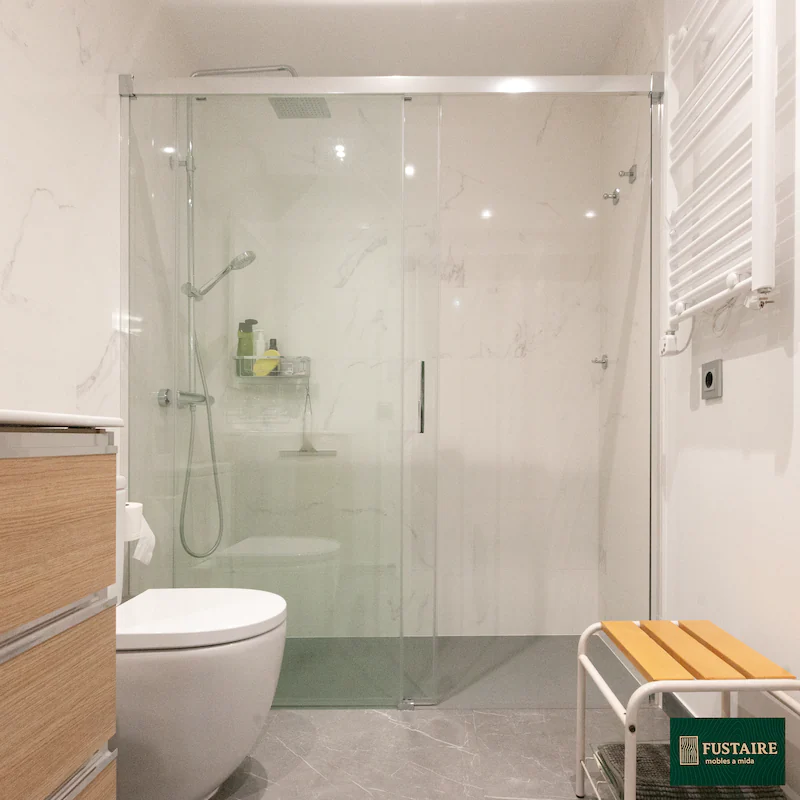 Reforma de baño moderno con mampara corredera y mueble de lavabo suspendido a medida en madera. Proyecto en Sarrià-Sant Gervasi, Barcelona, por Fustaire.